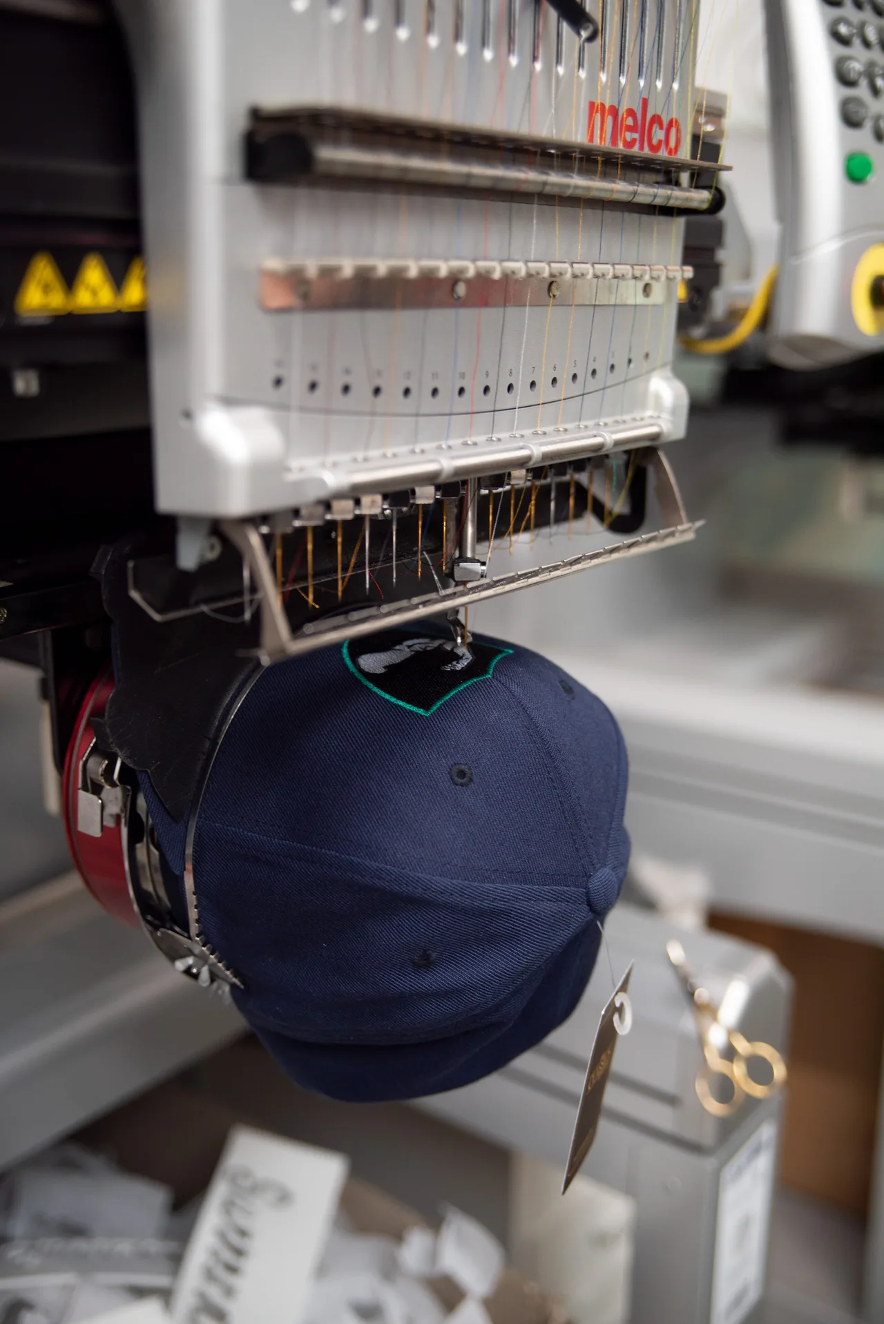 Stickmaschine bestickt eine dunkelblaue Cap mit einem Motiv